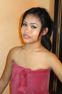 a young asian gal getting naked in the bed